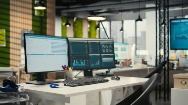 Boş şirket ofisinde yüksek teknoloji ve çift monitörler, iş stratejisi ve rapor yazma için hazır analitik araçlar bulunuyor. Profesyonel büyüme ve örgütsel başarı.
