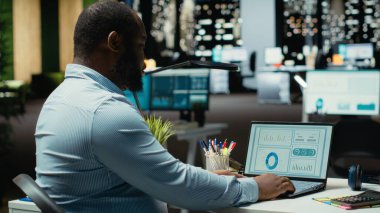 İş hedefleri için piyasa verilerini araştıran ve strateji oluşturan kara danışman, dizüstü bilgisayardaki hesap tablolarını düzeltme için kullanıyor. Çok uluslu bir şirket için fazla mesai..