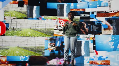 İçerik yaratıcısı mikrofonu kullanarak nüfuz eden yaşam tarzı ve sosyal ağ deneyimleri hakkında konuşuyor. Afro-Amerikalı kadın, seyircilerin önünde konferans sunumu yapıyor, videolar gösteriyor, kamera A