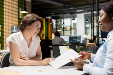 İş kadını, işe alım sürecinin bir parçası olarak emeklilik planları, sağlık aboneliği ve programın esnekliği de dahil olmak üzere bir şirkette işe alım görevlisiyle yaptığı toplantıda kariyer avantajlarından bahsediyor..