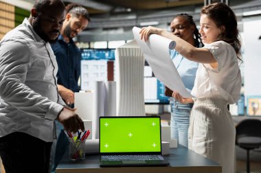 Emlak geliştiricileri ekibi, şehir planlama ve tasarım yoluyla yeni kentsel gelişim konut projesinde işbirliği yaparak, kopya uzay gösteriminin yanındaki planları inceliyor. Akıllı şehir.