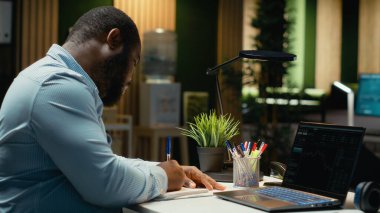 Afrika kökenli Amerikalı danışman hisse senedi ve ön ödeme verilerini inceliyor, iş gelişimini yönlendiren raporlar ve tahminler hazırlıyor. Geceleri modern bir yatırım stratejisi oluşturmak..