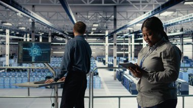 Veri merkezi teknisyenleri sistem incelemesi sırasında dizüstü bilgisayarı kullanarak Al 'ın gösterge panelini kontrol ediyor. Takım çalışması sunucu merkezi meslektaşları yapay zeka araçlarını test ediyor. Not defteri, kamera A