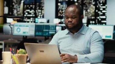 Saatler sonra erkek finans analisti belgeleri kontrol edip kopyalıyor, bilgisayarına önemli veriler yazıyor. Şirket hedefleriyle aynı hizaya getirmek için bir özet hazırlamak ve strateji tasarlamak. Kamera B.