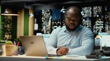 Öfkeli siyahi işadamı bir hata yaptıktan sonra kâğıt kırıyor, el yazısı ve mesai sonrası not tutuyor. Sabırsız çalışanın taslağı yeni bir sayfada yeniden düzenlemesinden memnun değilim. Kamera B.