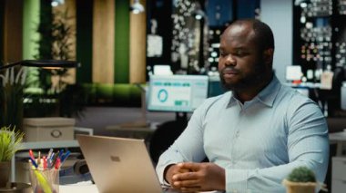 Siyahi iş danışmanı mesai bitiminden sonra online bir video görüşmesine katılıyor, hissedarlarla internet üzerinden görüşmelerine katılıyor. Ağ kurma seansındaki insanlarla iletişim kuran profesyonel bir adam. Kamera B.