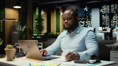 Saatler sonra erkek finans analisti belgeleri kontrol edip kopyalıyor, bilgisayarına önemli veriler yazıyor. Şirket hedefleriyle aynı hizaya getirmek için bir özet hazırlamak ve strateji tasarlamak. Kamera A.