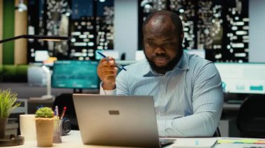 Siyah genel müdür taktiksel bir çözüm öngörüyor ve kalemle oynuyor, ofiste geç saatlere kadar çalışıyor. Adam eleştirel düşüncelere dalıp ikilem için seçenekleri ve çözümleri değerlendiriyor. Kamera B.