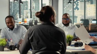 Çeşitli iş arkadaşları toplantıda strateji ve bütçeleme, verimlilik için öngörü planlarını tartıştılar. Şirket ekibi, kaynak tahsisi için performans ölçümlerini, raporları ve dosyaları değerlendirir. Kamera B.