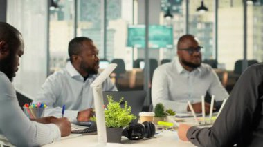 İş görüşmeleri sırasında fikir alışverişinde bulunan iş arkadaşları ve çalışanlar. Profesyonel ekip, kurumsal ilerleme hedefleri doğrultusunda finansal verileri, hedefleri ve iş istihbaratını inceler. Kamera B.