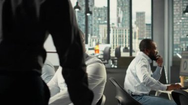 Ofisteki bilgisayarlarda iş arkadaşları raporları ve görsel verileri paylaşıyor. Çalışma ekibi, güçlü performans ve ilerlemeyi sağlamak için risk değerlendirmesi, strateji planlaması ve veri görselleştirmesi gerçekleştirir. Kamera B.