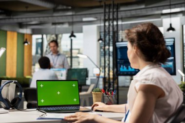 Dizüstü bilgisayardaki analizleri gözden geçiren, izole edilmiş bir model şablonu olan kadın ofis çalışanı. Modern çalışma alanında beyaz finans uzmanı yeşil ekran ekranlı dijital cihaz üzerinde çalışıyor.