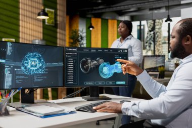 Yeşil teknoloji şirketindeki araştırmacı türbin bileşenlerini analiz etmek için yapay zeka kullanıyor. İşteki mühendis, PC 'de yapay zeka öğrenimini kullanarak, emisyonları azaltmak için türbin parçalarına bakıyor