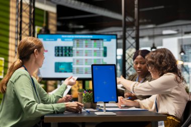 Çeşitli danışmanlardan oluşan bir ekip tablet üzerinde kopyalama alanının yanında bir strateji oluşturur, proje gündemini planlar ve toplantı odasında hedefler belirler. Ortaklar iş operasyonlarının verimliliğini gösteriyor.