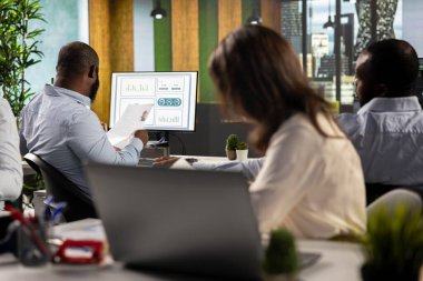 Ofiste birbirini selamlayan çok uluslu bir şirketteki iş arkadaşları, günlük işleri belgeler ve diyagramlarla çözmekle meşguller. Mesleki çeşitlilik gösteren çalışma ekibi kurumsal hedefleri tartışıyor.