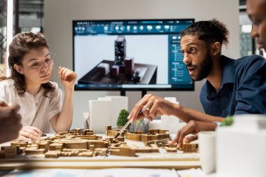 Müteahhitler ekibi kentsel kalkınma için yapısal 3D modeller planını gözden geçirir, gayrimenkul hedefleri ile şehir planlamasının sürdürülebilirliğini dengeler. Site hazırlığı.