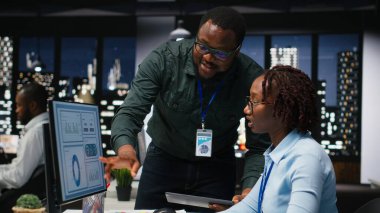 İşletme faaliyetleri için yeni bir strateji geliştirmeden önce, ofisteki masaüstü bilgisayarı ile ilgili veri içgörülerini analiz eden siyah iş arkadaşları ekibi, analiz tahminine danışıyor.