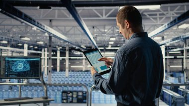 Sunucu odası bilişim uzmanı veri grafiklerini okumak ve ekipman sağlığını izlemek için tablet dokunmatik ekranından araklıyor. Yönetim, veri merkezinin hedeflere ulaştığından emin olmak için aygıt üzerindeki analiz ölçüm grafiklerini inceler, kamera A