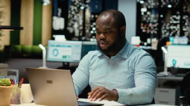 Afrika kökenli Amerikalı bir adam, ofisteki gece lambasının ve dizüstü bilgisayarın yeni bir perspektif için strateji kurup işlerini bitirdiğini fark ediyor. Gece geç saatlerde ofiste çalışmak. Kamera B.