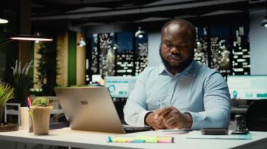 El yazısı özeti hazırlayan Afrikalı Amerikalı bir adam. Ofiste saatler sonra son gelişmeleri yazıyor. Günlük planlama, iş hedefleri ve gündem belgelerinin sağlanması. Kamera A.