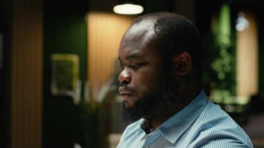 Yorgun erkek işçi gece geç saatte ofiste uykulu, yoğun iş yoğunluğu nedeniyle zihinsel bulanıklık ve yorgunluk yaşıyor. Huzursuz ve gergin hisseden bir adam. Kamera B.