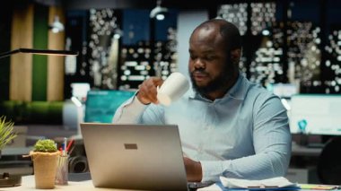 Afro-amerikan işçiler kahvelerini yudumluyor ve kapanış ofisini kuruyor, geç saatlerin farkına varıyor ve ayrılma işini bitiriyor. Genç çalışanlar fazla mesaiden sonra evlerine dönüyorlar. Kamera B.