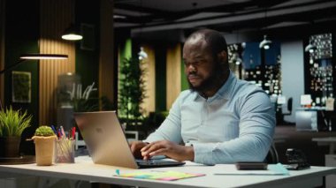 Afrikalı Amerikalı bir adam e-postaları cevaplıyor ve çok uluslu bir şirket için internetteki bilgileri belgeliyor, karanlık bir ofiste saatler sonra çalışıyor. Atılgan 'ın hedefleri ve gelişimi. Kamera A.