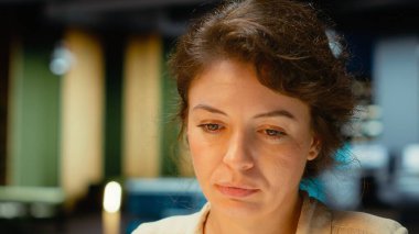 Dizüstü bilgisayarındaki bir sunum için notlar yazan kadın yönetici, finans belgelerinden önemli ayrıntıları ayıklıyor ve iş hedefleri ve yaklaşan görevler için özet çıkarıyor. Kamera B.