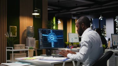 Ofis çalışanı AI analitik platformu ile aylık veri raporlarını kontrol ediyor, nöral ağ algoritmalarını gözden geçiriyor ve iş verimliliği için otomasyonu inceliyor. IT şirketinin temsilcisi.