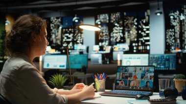 Yetkili yönetici, Webinar video görüşmesinde brifing veriyor. Ofiste saatler sonra son rapor verilerini paylaşıyor. Gece yarısı web konferansında ortak toplantı. Kamera A.