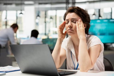 Kafkasyalı şirket çalışanı ofis masajlarında oturuyordu, baş ağrısı çekiyordu. Masadaki kadın yönetici, pazarlama firmasındaki bütçe planlamasından dolayı yorgun ve stresli hissederek gözlerini kapatıyor..