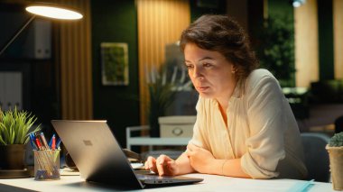 Heyecanlı çalışan gecenin geç saatlerinde bildirimden iyi haberler okuyarak kariyerinin gelişmesini ve ofisteki müthiş fırsatı kutluyor. Gururlu iş kadını ışıldıyor. Kamera B.