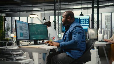 Boynu tutulmuş, sırt ağrısı olan, kaslarını esneten, iş yaparken kötü duruşunu düzelten Afrikalı Amerikalı bir adam. Organizasyon başarısına odaklanma.