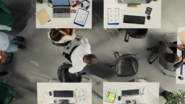 İş stratejisi ve piyasa araştırmaları hakkında konuşmak için ofisten uzaklaşın. Çeşitli iş arkadaşları hedefleri, hedefleri ve performans ölçülerini belirlemek için belge ve şemaları değerlendirirler. Kamera A.