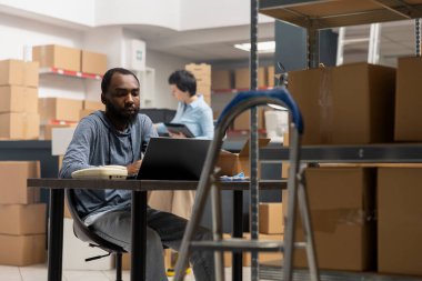 Kara depo işçisi, kargo ve nakliye lojistiği, envanter ve el eşyaları koordinasyonu, endüstriyel depo rafları. Masada ekspres teslimat servisi.