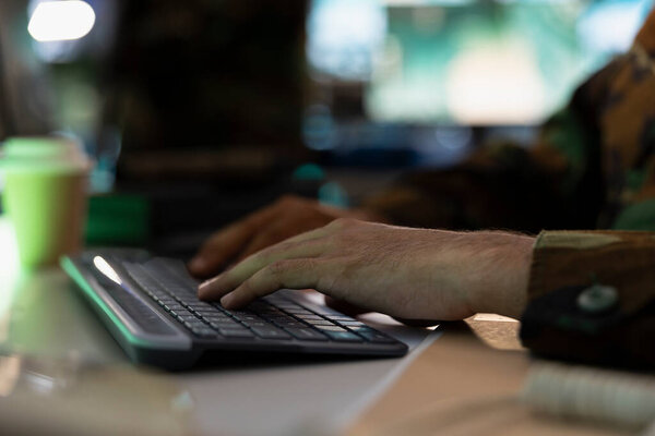 Military officer typing on keyboard, sending battlefield information to army decision maker. Close up shot of counterintelligence expert talking with general, showing enemy coordinates