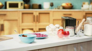 Modern bir tezgahta pizza malzemeleriyle donatılmış rahat bir mutfak. Peynir, domates ve biber kâseleri baharat ve mutfak malzemelerinin yanında oturur, eğlenceli bir hafta sonu yemeği aktivitesine hazırdır..