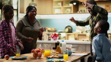 Afro-Amerikan ailesi kahvaltıdan sonra mutfakta dans edip şarkı söylüyor ebeveynler aptalca davranıp çocuklarını güldürüyor ve eğlendiriyorlar. Anne ve baba evde çocuklarıyla kaynaşıyor. Kamera B.