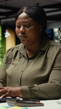 Dikey Video Kadın Danışmanı, gece vakti karanlık bir ofiste çalışan çok uluslu bir şirket için e-postaları okumak ve güncellemeleri belgelemekle meşgul. İş hedefleri ve proje geliştirme üzerine odaklanır