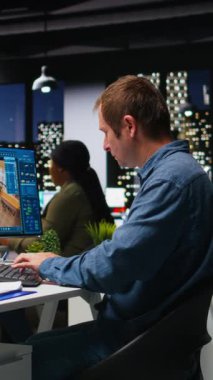 Dikey Video Çeşitliliği mühendisleri yapay zeka sinirsel ağlarını kullanarak yeni bir apartman binasının iç tasarımı, iş yerindeki bir kat planı için mimari yazılım oluşturuyorlar. Çift ekran. Kamera.