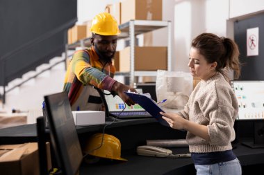 Küçük işletme çalışanları karton kutuları etiketler ve etiketler için tarıyor, hızlı teslimat ve e-ticaret siparişleri için paketler hazırlıyorlar. Küçük ölçekli bir depoda perakende ürün dağılımı.