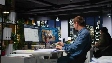 Çift ekran monitörlerde mimari yazılımlar kullanarak üç boyutlu bir iç mimari tasarım yaratıyor. Geliştirici, dizayn etmek ve varlıkları yerleştirmek için dijital araçlar kullanır. Kamera A.