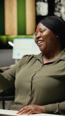 Dikey Video Girişimcisi telefonda konuşurken gülümsüyor video görüşmesi, dikkatlilik ve profesyonellik. Siyah kadın sanal sohbete daldı, katılımcılarla fikir alışverişinde bulundu.