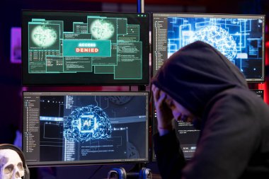 Hassas bilgileri çalmaya çalışırken bilgisayardan gelen mesajı reddettiği için üzgün bir hacker. Düzenbaz programcı, yapay zeka kullanarak sistem hatalarını kullanamadığı için üzgün.