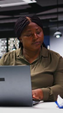 Dikey Video Siyah Şirketi çalışanı bir dizüstü bilgisayarda pazar araştırması ve grafiklerini kontrol ediyor, çalışma alanındaki veri görselleştirmeleri ve raporlarını inceliyor. Hedefler için kaynak tahsisi stratejisi