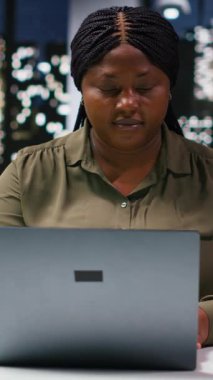 Strateji brifinginde dosya ve çizelgeleri inceleyen dikey video çeşitliliği iş arkadaşları. Çokuluslu şirketteki çalışanlar, bilgisayar ve görsel veri araçları kullanarak bilgi paylaşımı ve görevleri koordine ederler