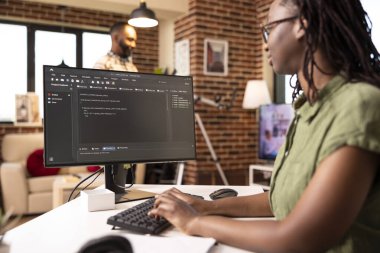 Kadın programcı, erkek arkadaşı televizyon izlerken internet sitesi kodu yazmaya odaklanmış. Afrikalı Amerikalı teknoloji girişimcisi bilgisayarla uzaktan yazılım geliştiriyor.