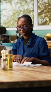 Dikey Video Genç çifti harcamaları takip ediyor ve ev işlerini birlikte yapıyorlar. Mutfak masasında makbuzlar, hesap makinesi ve dizüstü bilgisayarla birlikte oturuyorlar. Faturaların hesaplanması, sorumlu mali planlama