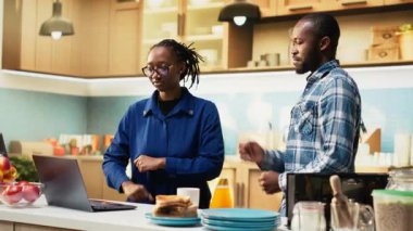 Gülümseyen siyah adam ve kadın mutfakta romantik bir dans paylaşıyor, tutkulu bir aşk şarkısında vals yapıyor ve birbirleriyle flört ediyorlar. El ele tutuşmak, yavaşça dans etmek, sallanmak. Kamera B.