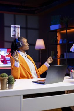 Boş zamanlarında neon ışıklı apartman dairesinde enerjik müzik dinleyen keyifli genç, coşkulu. Evdeki sandalyede dans eden mutlu genç kız, kulaklıklardan neşeli şarkılar duyuyor.